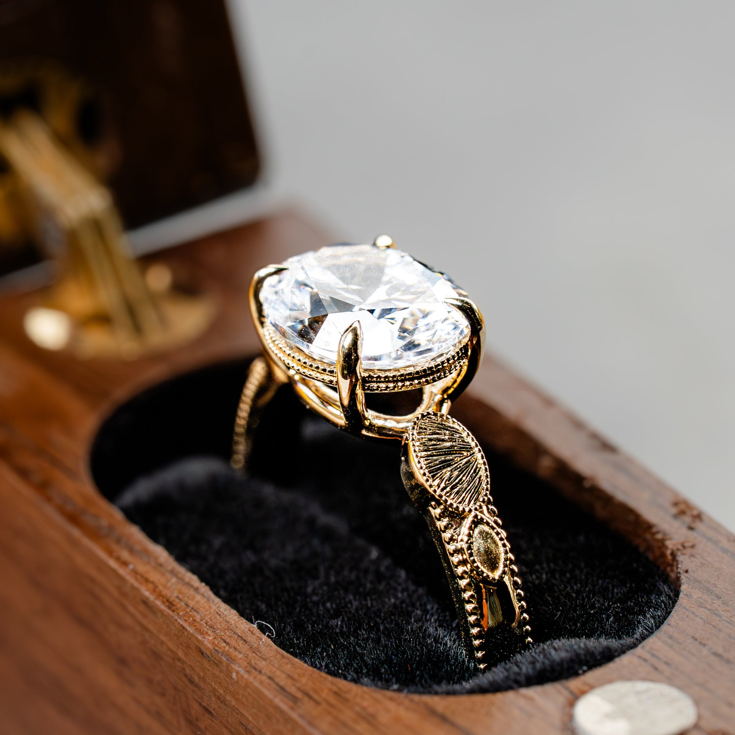 Gold ring with a large diamond on a wooden stand