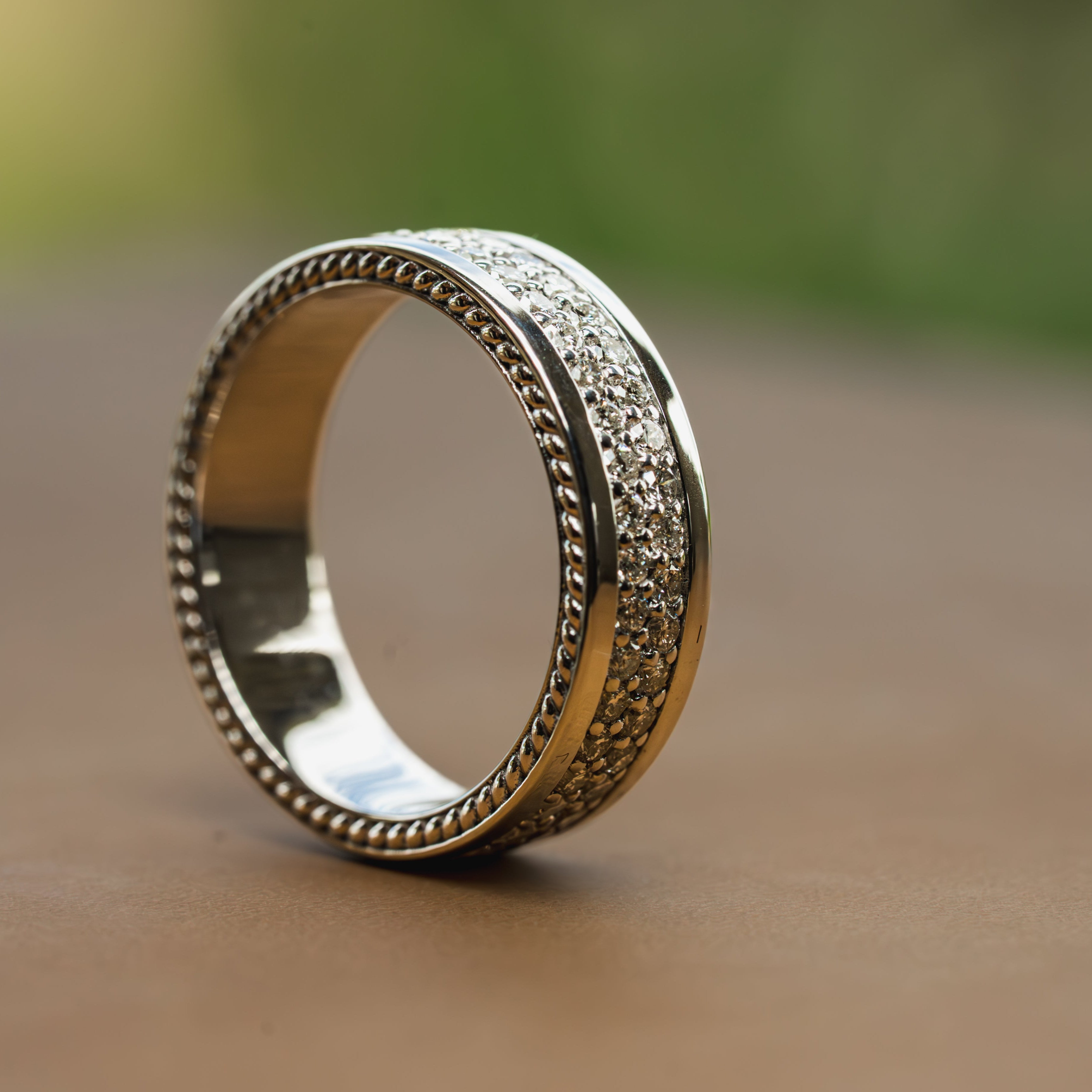 Silver ring with 100+ Diamonds and intricate design on a wooden surface