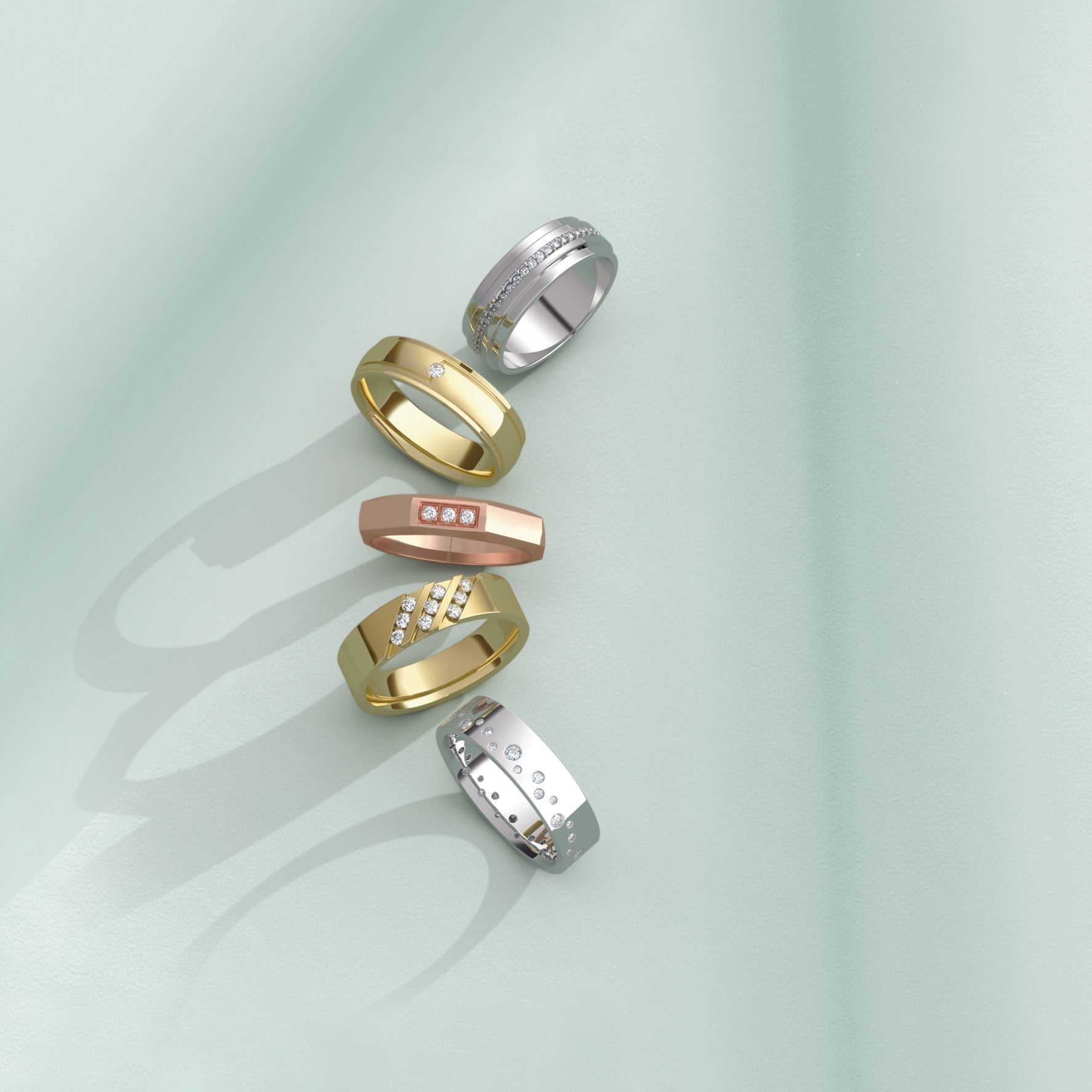 Set of gold and silver rings on a light green background